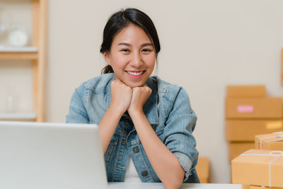 Portrait of a smiling young woman using phone