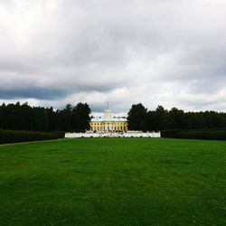 View of castle on field against cloudy sky