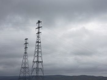 Low angle view of electricity pylon against sky