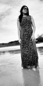 Woman standing on beach against sky