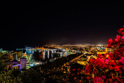 High angle view of illuminated buildings against sky at night