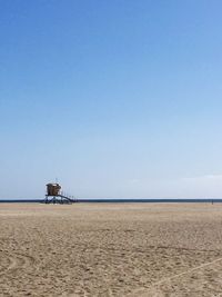 Scenic view of beach against clear blue sky