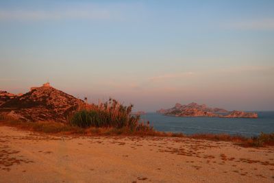 Scenic view of beach against sky during sunset