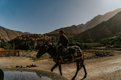 Man riding motorcycle on mountains against sky