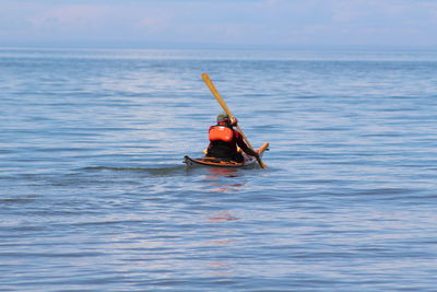 Rear view of man kayaking on lake