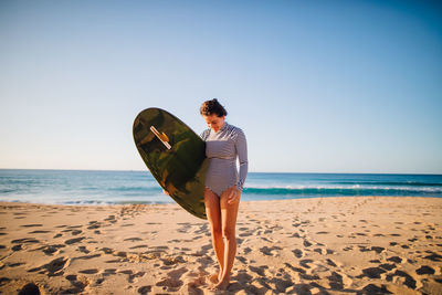 Man standing on beach against clear sky