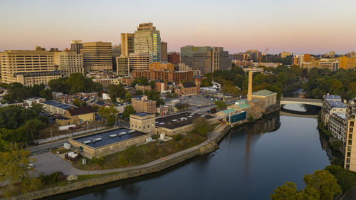 High angle view of river and buildings against sky at sunset