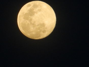 Low angle view of full moon against clear sky at night