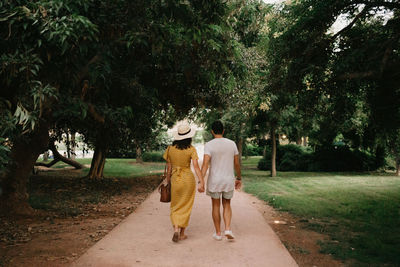 Rear view of couple walking on footpath