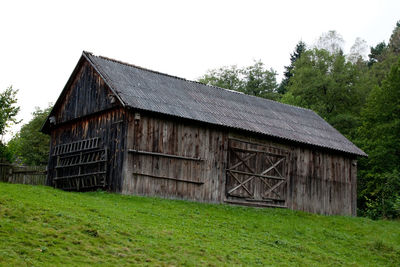Old barn on field against clear sky