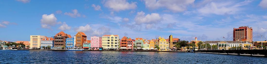 Panoramic view of river amidst buildings against sky