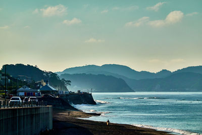 Scenic view of sea and mountains against sky