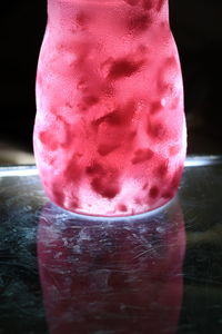 Close-up of pink water in glass