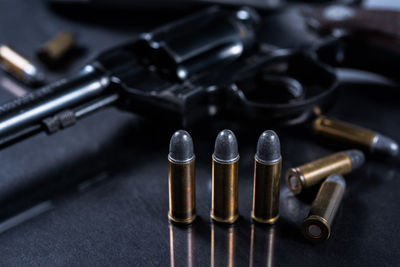 Close-up of bullets and handgun on table