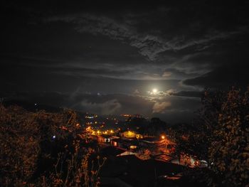 Illuminated city against sky at night