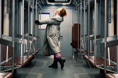 Rear view of man standing in train