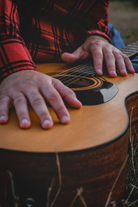 Midsection of man playing guitar