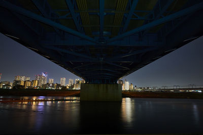 Illuminated bridge over river at night