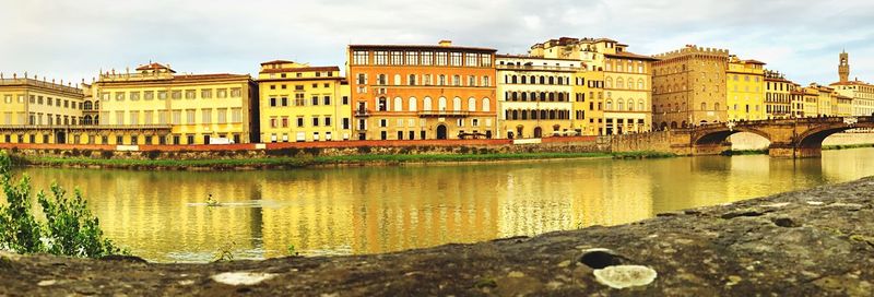 Bridge over river against buildings in city