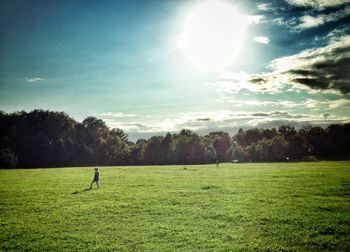 Scenic view of grassy field against cloudy sky