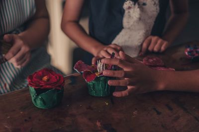 Midsection of people doing craft on table