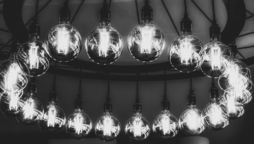 Low angle view of illuminated chandelier hanging from ceiling