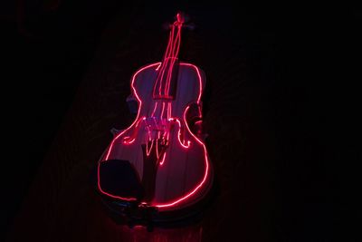 Illuminated guitar on black background