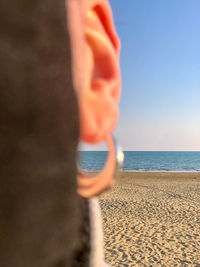 Midsection of person on beach against sky