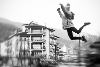 Woman jumping against clear sky