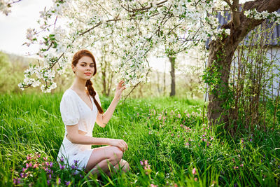 Portrait of young woman sitting on field