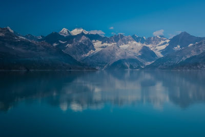 Scenic view of lake and mountains against blue sky