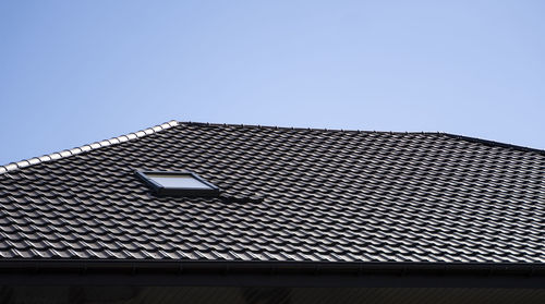 Low angle view of building roof against clear sky