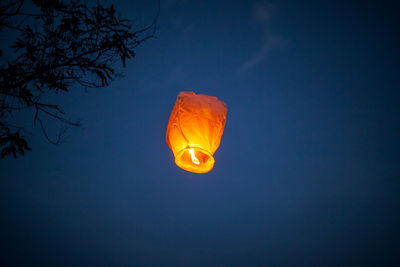 Low angle view of illuminated lamp against sky at night