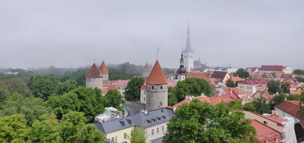 Panoramic view of buildings and trees against sky