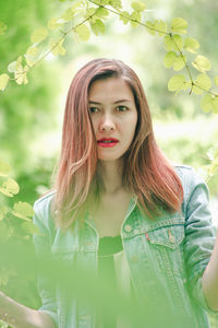 Portrait of beautiful woman standing against plants