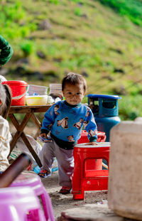 High angle view of cute boy playing with toy while standing outdoors