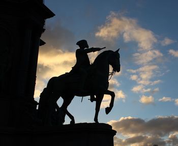 Silhouette of statue against sky at sunset