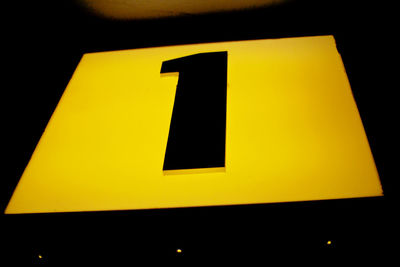 Close-up of yellow sign on black background