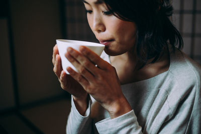 Mid section of man holding coffee cup