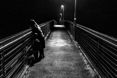 People on illuminated footpath at night