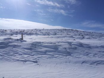 Snow covered landscape against sky