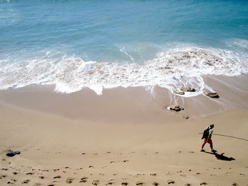 High angle view of man walking on beach