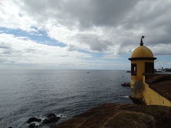 Scenic view of sea by building against sky