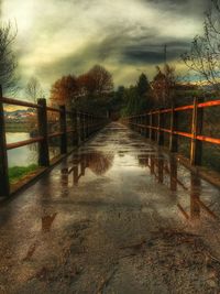 Bridge over river against cloudy sky