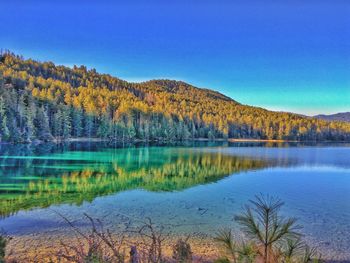 Scenic view of lake against clear blue sky