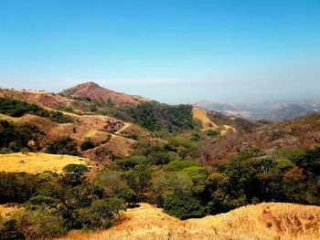 Scenic view of mountains against clear blue sky