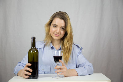 Portrait of a smiling young woman holding drink