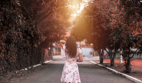 Rear view of woman standing amidst trees