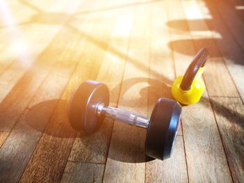 High angle view of dumbbell of kettlebell on hardwood floor