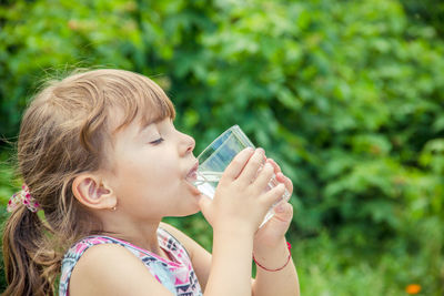 Portrait of young woman drinking water from bottle